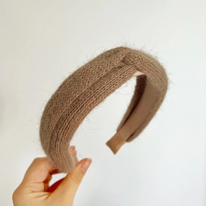Detail of milk tea brown plush cross-knotted headband with soft fuzzy texture
