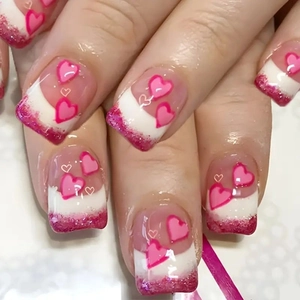 Short French press-on nails with sweet pink hearts and glitter tips for Valentines Day