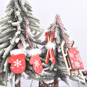 Three-piece wooden Christmas pendants with red gloves, skis and sled on snowy tree