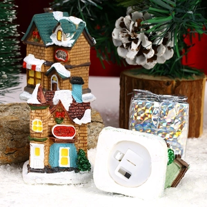 Light-up resin Christmas village scene with miniature snowy houses and festive ornaments