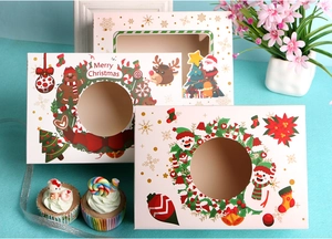 Detailed view of Christmas cupcake boxes with festive patterns and clear windows