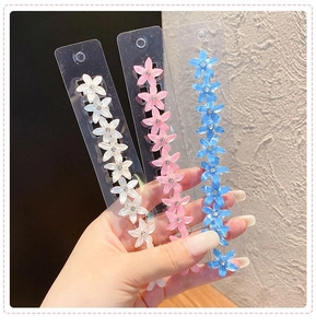 Vue détaillée de pinces à fleurs colorées en résine avec strass étincelants
