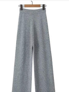 Detail view of grey knit wide-leg trousers with high waist and ribbed texture design