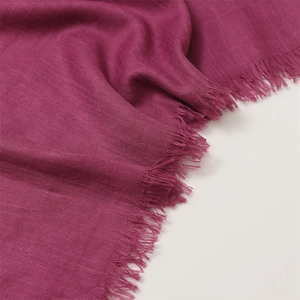 Detail of fuchsia cotton linen scarf with soft fringe edges and woven fabric texture