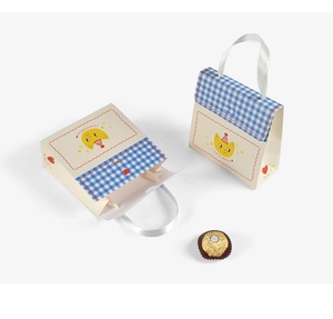 Detail of cream gift box with blue check pattern, cartoon cat print and white satin handles