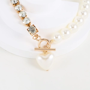 Detail of gold OT toggle clasp and white heart pearl pendant on rhinestone necklace