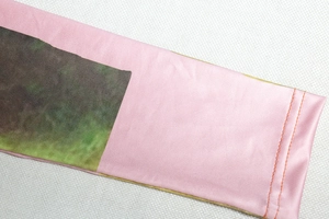 Dettaglio della maglia rosa tie-dye a maniche lunghe con trama del tessuto e cuciture
