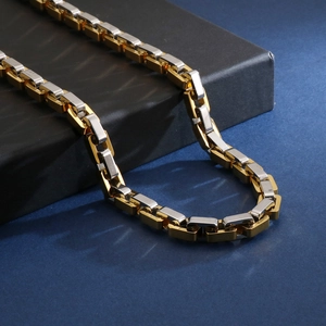 Makro-Detail der zweifarbigen gold-silbernen geometrischen Gliederkette aus Edelstahl