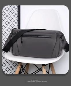 Detail of dark gray waterproof nylon shoulder bag with side pocket and zipper on modern chair