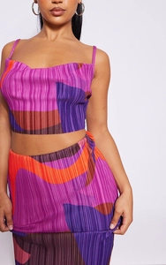 Detailed view of the pleated fabric with an abstract wavy print in purple and orange