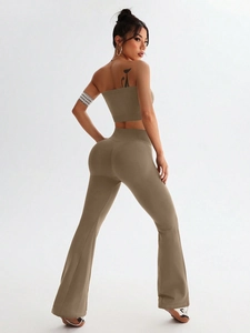 Detail of high-waisted flared yoga pants and crop top set in seamless khaki fabric