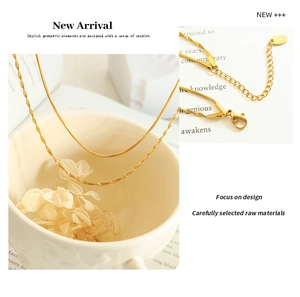 Detail of gold double-layer snake chain necklace showing lobster clasp and extender