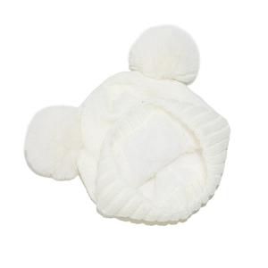 Dettaglio del cappello in maglia bianca con fodera in pile e due pompon per bambini