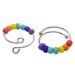 Detail of adjustable silver rings with rainbow beads in wrap and spiral wire designs