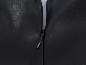 Detail of lychee textured PU leather fabric and black invisible zipper on the mini dress