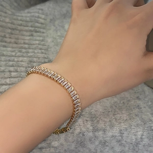 Close-up of gold plated bracelet with rectangular zircon stones worn on wrist