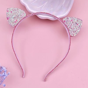 Pink glitter cat ear headband with sequins and bow detail on a soft pink background