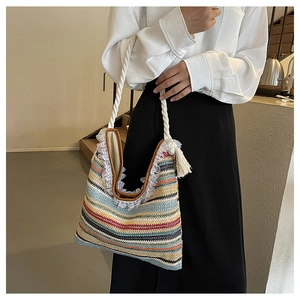 Detail of colorful woven straw tote bag with white lace trim and tassel accents