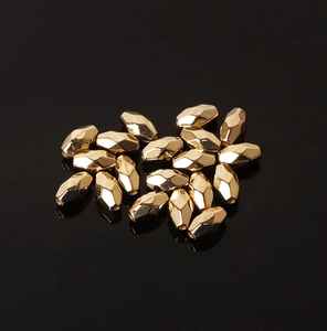 Macro shot of faceted gold CCB spacer beads for DIY jewelry making on black background