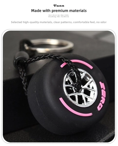 Close-up of racing tire keychain with pink stripe design and metal rim detail