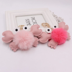 Detail of pink and rose plush crab keychains with PU leather claws on white background