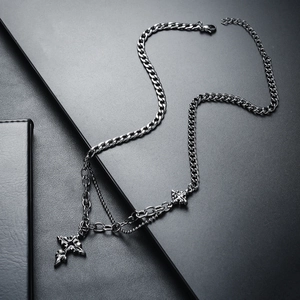 Detail of silver titanium steel cross pendant on double-layer cuban and bead chains