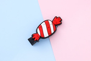 Detail of red and white candy silicone hairpin with black metal duckbill clip for kids