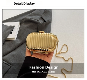 Detail of gold acrylic evening clutch bag with vertical wave pattern and metal chain