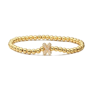 Detailed view of a gold beaded bracelet featuring a sparkling zircon flower charm