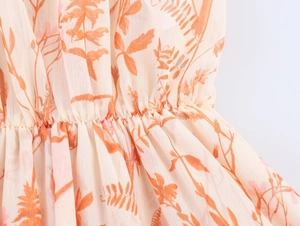 Detail eines Boho-Chiffonkleids mit Blumendruck und elastischem Taillendesign in Orange