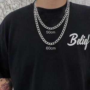 Detail view of 50cm and 60cm silver titanium steel Cuban chain necklaces on a model