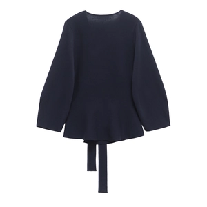 Detailed view of dark blue knit top featuring a peplum hem and matching tie belt