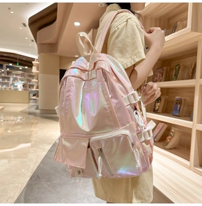 Detail of pink laser iridescent backpack showing side buckles and functional zipper pockets