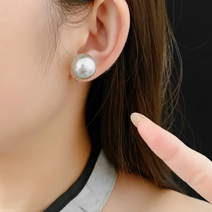 Detailed view of a 16mm silver-grey pearl ear clip on a model with elegant luster