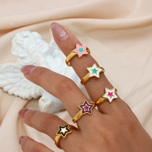Detailed view of colorful star enamel rings in gold finish worn on fingers