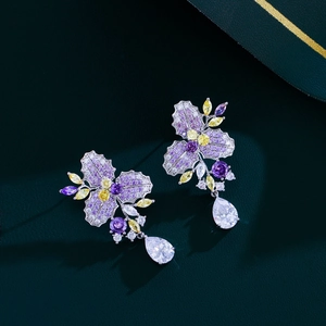 Detail of floral earrings with purple and yellow zircons and a pear-shaped drop