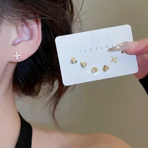 6-piece gold earring set with heart, cross and square studs for women on card