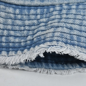 Macro shot of blue denim fisherman hat featuring trendy frayed edges and reinforced stitching