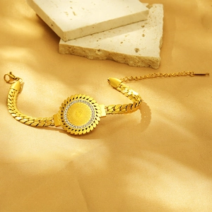 Detail of 18K gold-plated Cuban chain bracelet with relief coin and white crystals