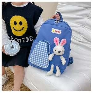 Close-up of kids royal blue backpack with plush bunny and checkered pocket detail