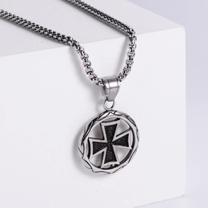 Minimalist stainless steel cross necklace on geometric display with industrial aesthetic