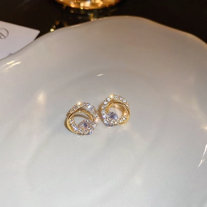 Macro detail of gold-plated geometric interlocking hoop earrings with sparkling cubic zirconia