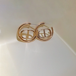 Elegant gold-tone hoop earrings with geometric CD letter design and polished metal finish