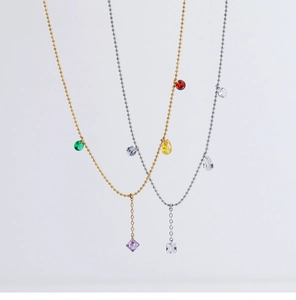 Detail of gold and silver beaded necklaces with colorful gemstone fringe pendants