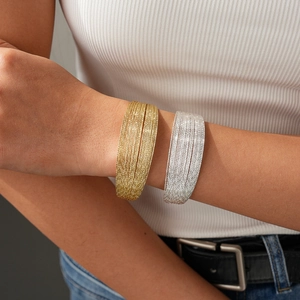 Minimalist multi-layer geometric metal cuff bracelets in gold and silver finish on wrist
