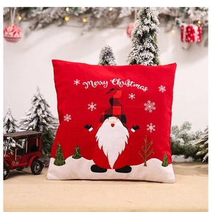 Close-up of a red Merry Christmas gnome pillowcase on a festive linen background
