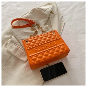 Detail of orange quilted PU leather shoulder bag with gold chain and FASHION embossing