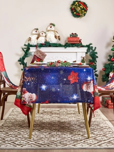 Detailed close-up of a Christmas tablecloth with Santa Claus and snowflakes on a dark blue background
