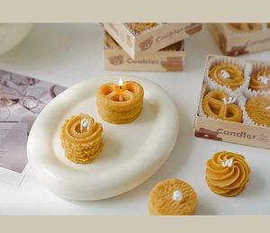 Detalle de velas con forma de galleta en una bandeja con caja de regalo artesanal