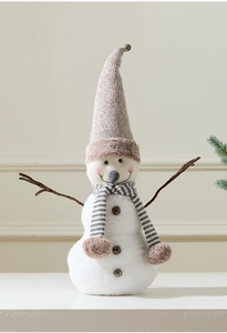 Detail of Christmas snowman plush with knit hat, striped scarf, and branch arms